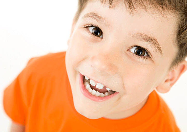 child smiling exhibiting teeth gaps