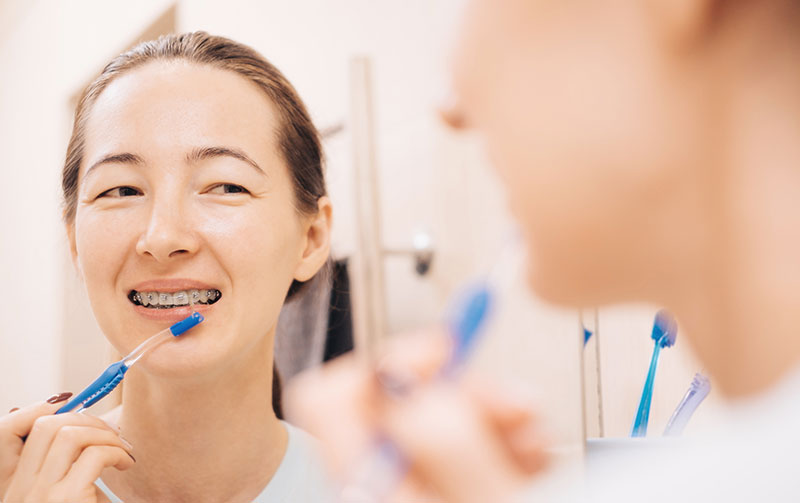 lady looking at mirror with braces