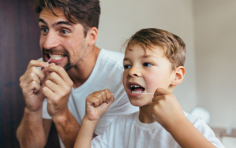 Parent helping to floss