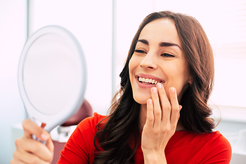 lady looking at mirror smiling